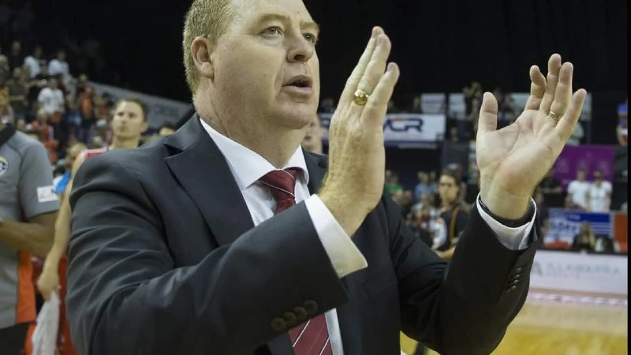 Rob Beveridge applauding courtside during a game